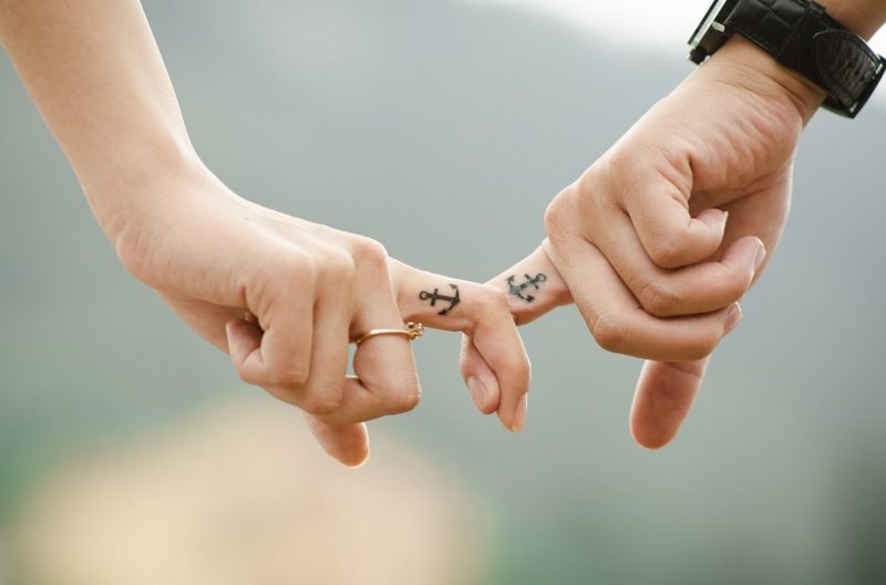 Dos personas que se dan la mano en una relación de pareja