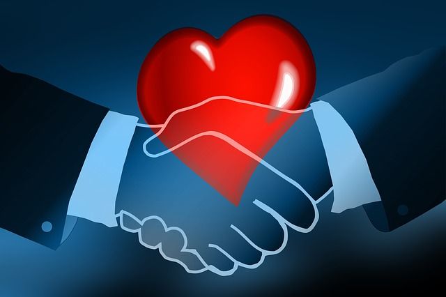 Dos manos estrechándose y un corazón representando los hábitos de vida saludable