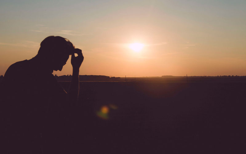 Persona sola al atardecer padeciendo un trastorno estrés postraumático